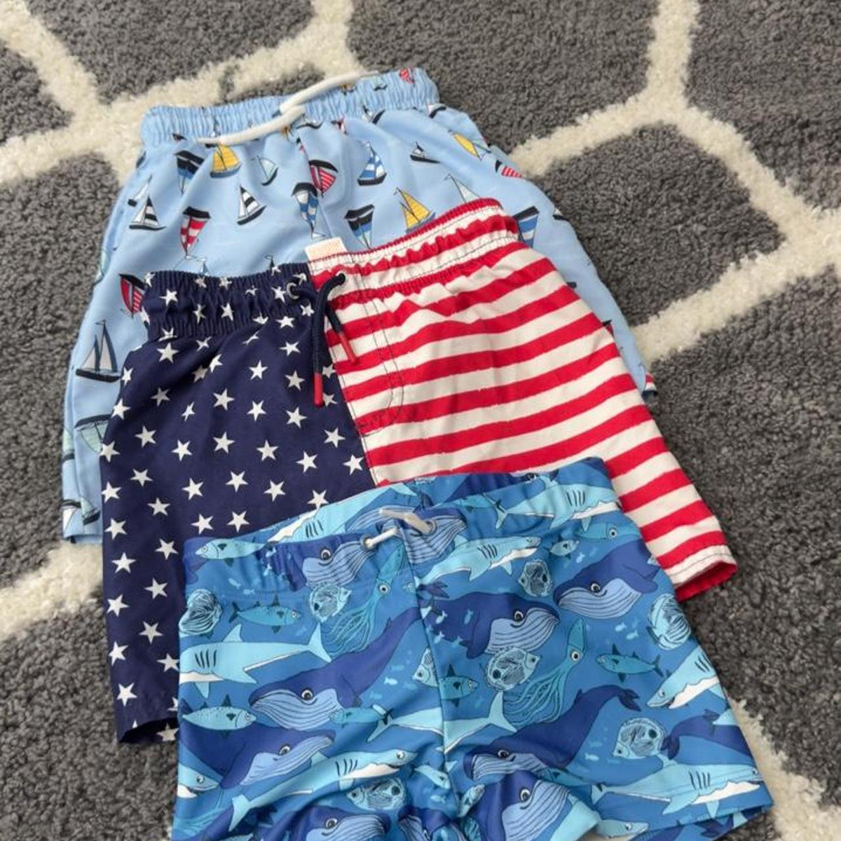 3 assorted pack of boys swim trunks with sailboats, stars, stripes, and sharks. Size 4-6 years. #swimwear #boys - Image 1